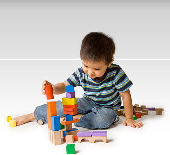 Preschool boy playing with wooden blocks.